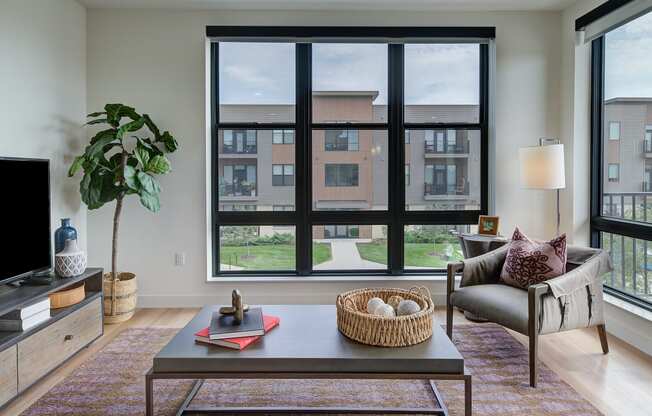 a living room with a large window and a couch and a table at Statesman Apartments, Wisconsin