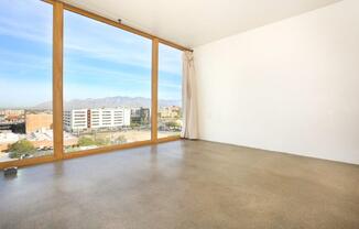 A room with a large window overlooking a cityscape.