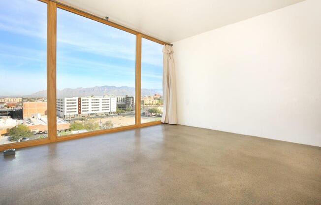 A room with a large window overlooking a cityscape.