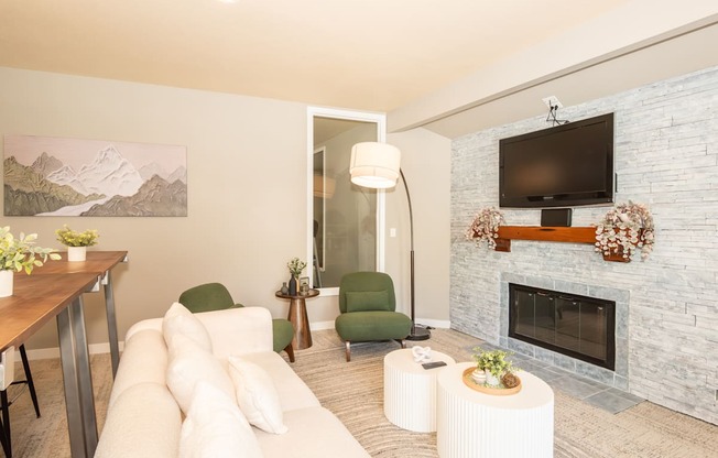 A living room with a fireplace and a painting of a mountain scene on the wall at Sunstone Parc, Beaverton, OR, 97008
