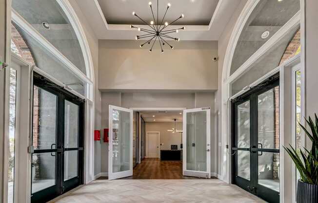 a foyer with glass doors and a chandelier