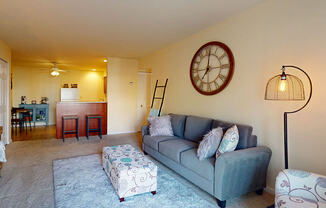a living room with a couch and a clock on the wall