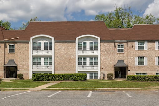 A large brick building with a parking lot in front.