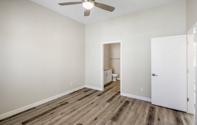 a bedroom with hardwood floors and a ceiling fan