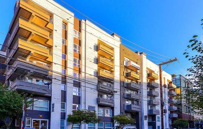 a row of apartment buildings with a blue sky in the background