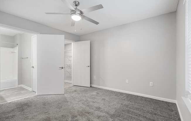 an empty room with white walls and a ceiling fan