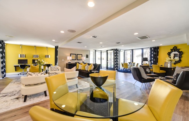 Community leasing office with bright yellow accent walls and yellow chairs around a round glass table