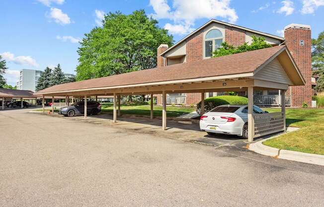 A car is parked in a parking lot under a covered structure.