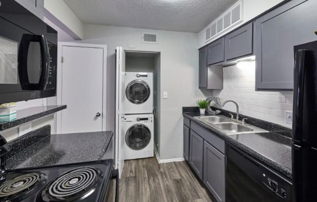 a kitchen with a washer and dryer and a sink