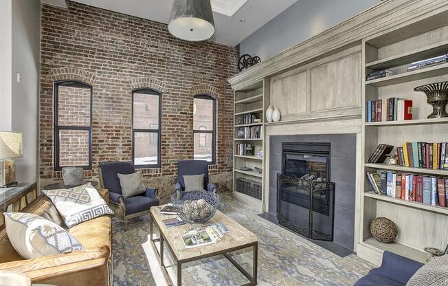a living room with a brick wall and a fireplace