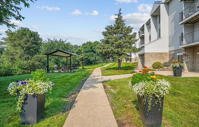 A sunny day at a residential area with a walking path and flower pots.