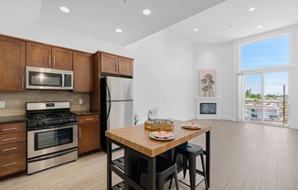 A kitchen with a table and chairs in front of a window.