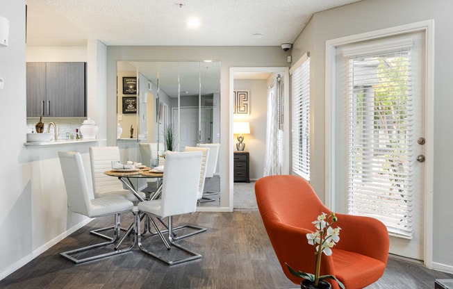 a living room and dining room with a table and chairs