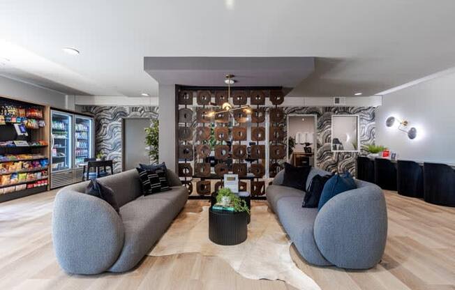 a living room with two gray couches and a wall with a mural