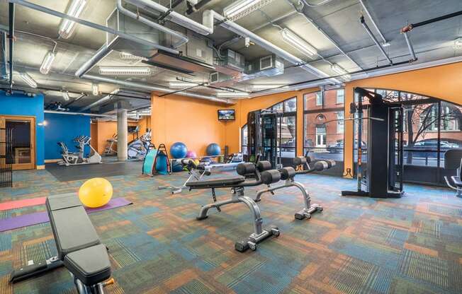 Fitness room with orange and blue walls and lots of different equipment