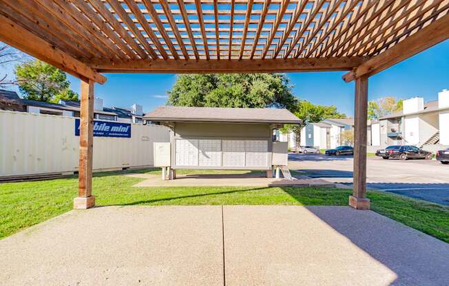 A wooden pergola is over a concrete patio.