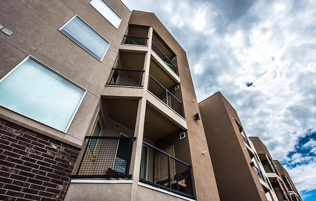 A tall apartment building with balconies and windows.