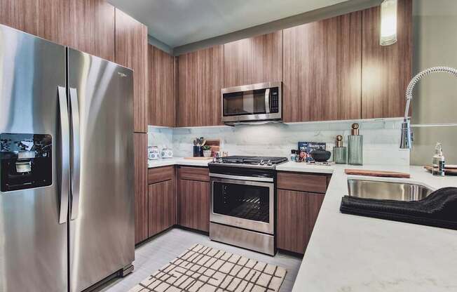 A modern kitchen with wooden cabinets and stainless steel appliances.