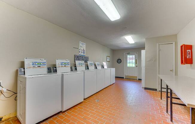 A room with a row of refrigerators and a fire extinguisher at Copper Hill Apartments, Bedford