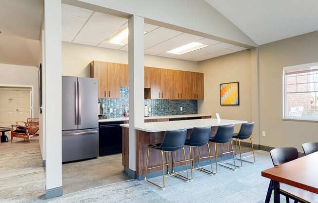 Community clubhouse kitchen with refrigerator and island seating for resident use in the clubhouse at The Northbrook Apartments