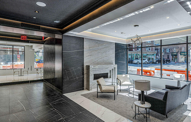 Lobby of 3thirty3 New Rochelle NY high-rise. Features fireplace, marble floors, modern seating, and floor-to-ceiling windows with street view.