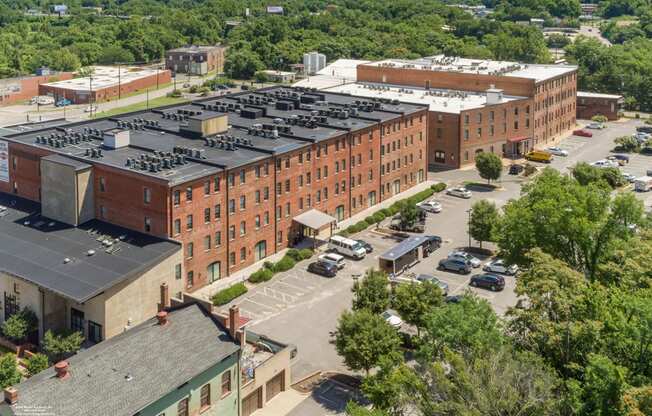 an aerial view of a large brick building with a parking lot at Mayton Transfer Lofts, Virginia, 23803