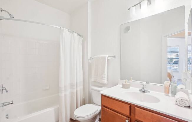 A white bathroom with a toilet, sink, and bathtub.