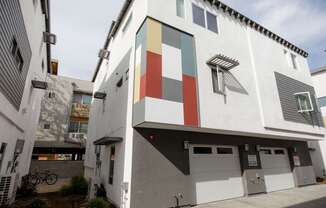 A white building with a red, green, and blue square on the side.