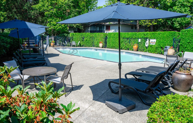 a swimming pool with umbrellas and chairs around it Copper Ridge Apartments, Renton, 98055