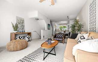 a living room with a beige couch and a black and white rug