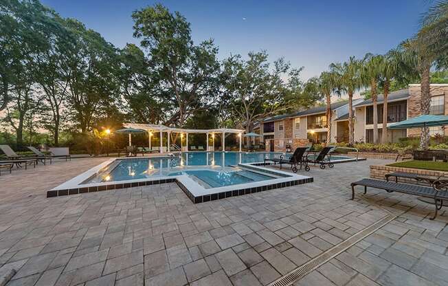 Community Swimming Pool with Pool Furniture at Grand Pavilion Apartments in Tampa, FL.