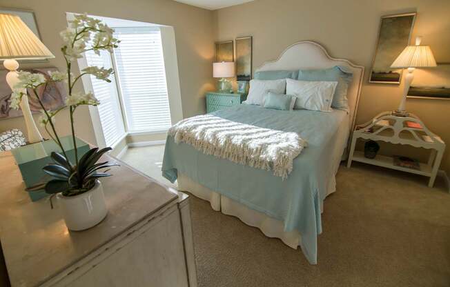 A bedroom with a bed, nightstand, and lamp.