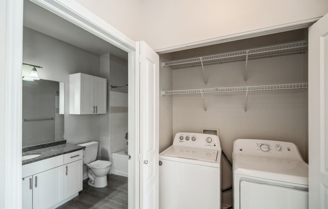 a kitchen with a washer and dryer and a toilet
