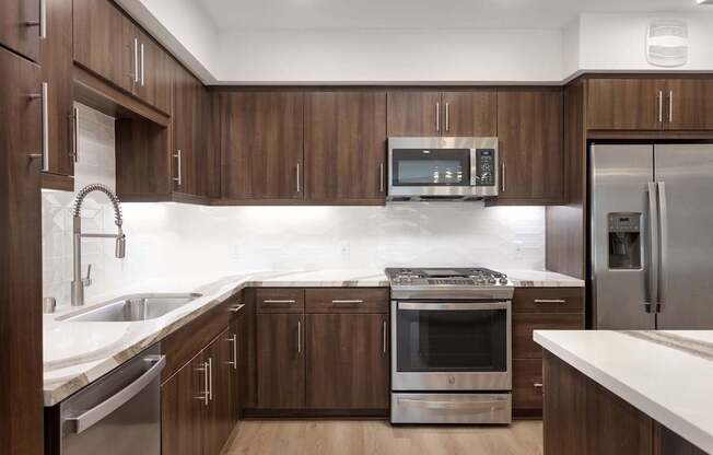 A modern kitchen with wooden cabinets and stainless steel appliances. at Elements Apartments*, California