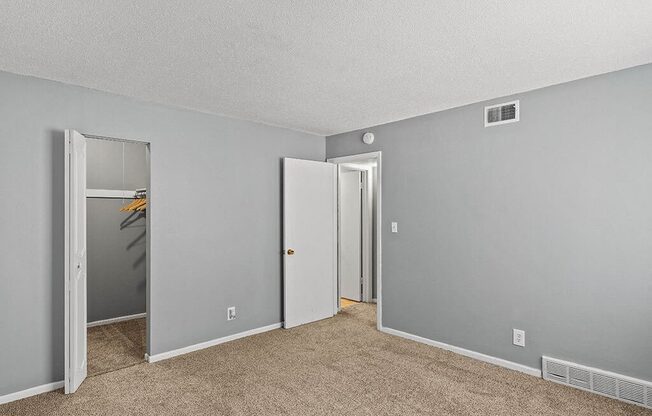 an empty living room with a door to a closet