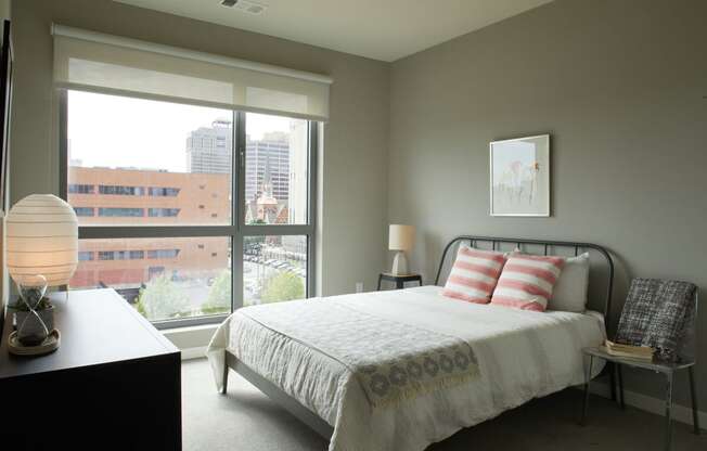 a bedroom with a bed and a large window