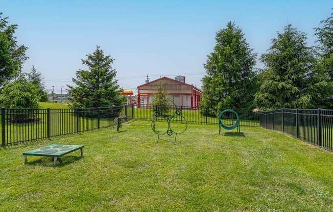 a yard with a swing set and a fence with a house in the background