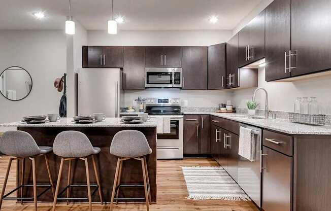 a kitchen with stainless steel appliances and wooden cabinets. Circle Pines, MN Lexington Lofts