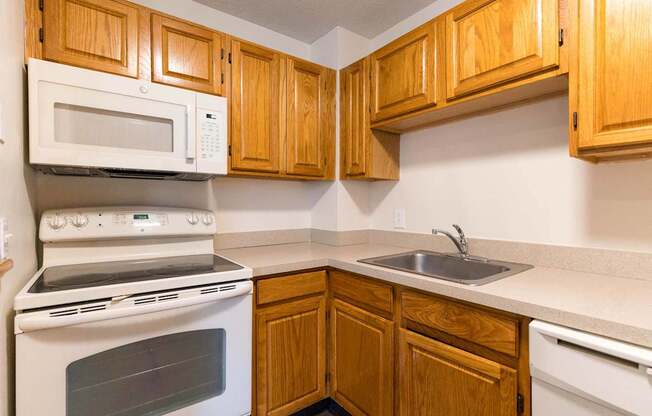 A kitchen with wooden cabinets and a white oven.