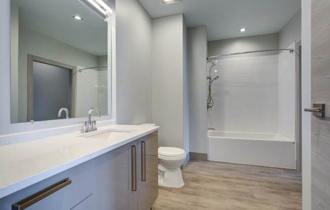 A white bathroom with a toilet, sink, and bathtub.