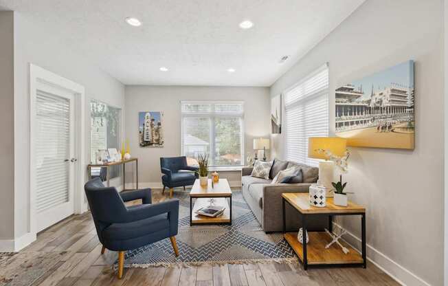 A living room with a blue chair and a grey couch.
