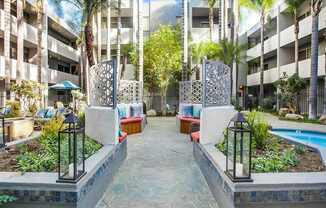 A courtyard with a pool surrounded by buildings and trees.