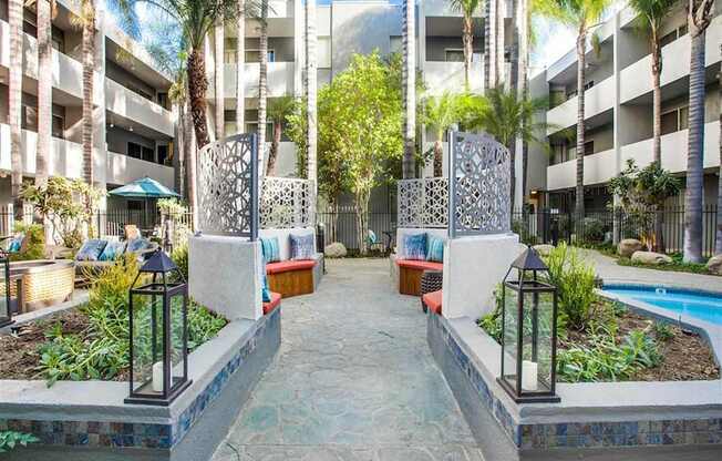 A courtyard with a pool surrounded by buildings and trees.