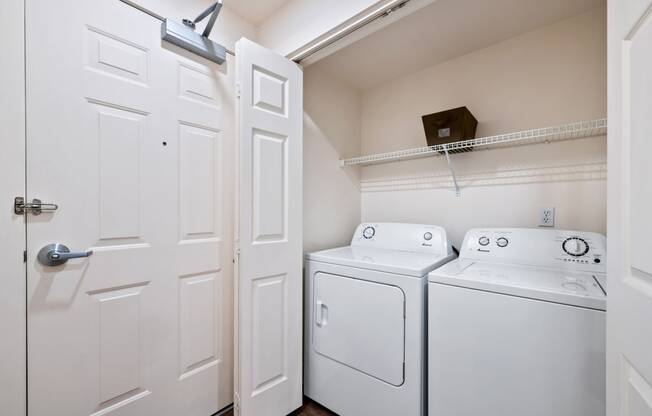 Full size washer and dryer in laundry closet with shelving