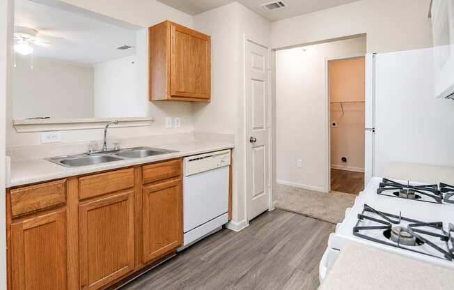 A kitchen with wooden cabinets and a white stove top oven.