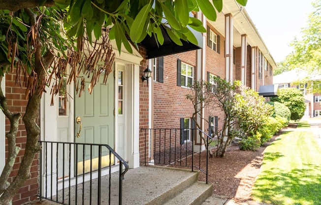 a building with a green door and a tree in front of it