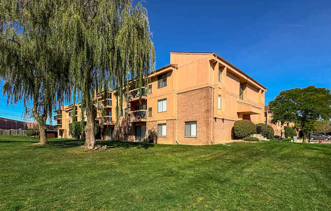 A large building with a green lawn in front.