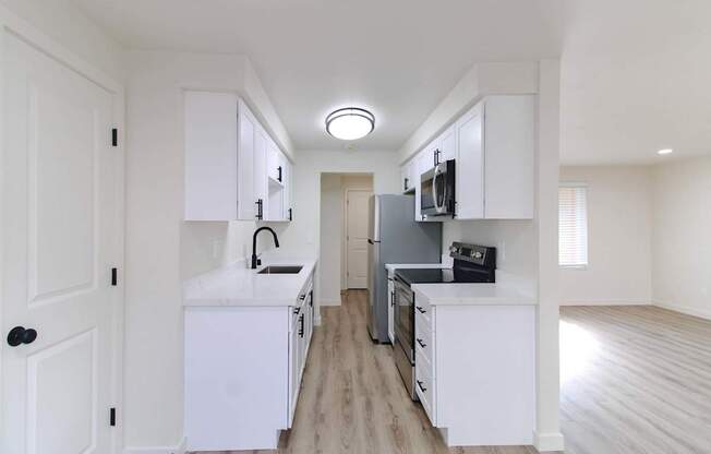Renovated kitchen with white cabinets and black fridge at Melrose on 91 in Redmond, WA