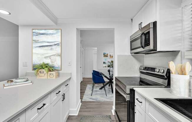 A kitchen with a white counter top and a blue chair.