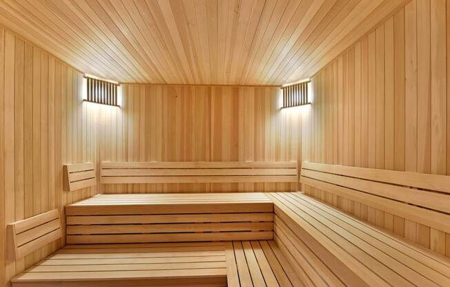 A wooden sauna with benches and lights on the wall.